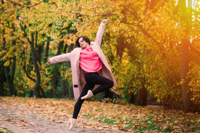 Full length of young woman jumping in park