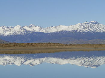 Scenic reflection of snowed mountains in calm lake