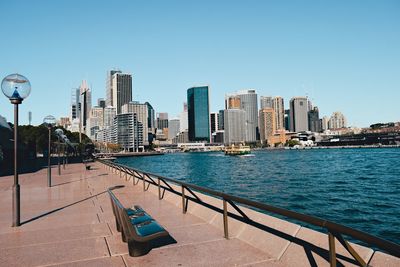 View of sydney skyline at waterfront against blue sky