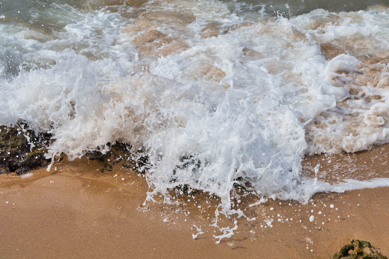 HIGH ANGLE VIEW OF WAVES SPLASHING ON SEA