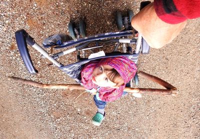 High angle view of man pushing girl on baby stroller