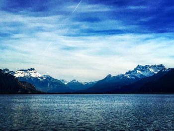 Scenic view of lake and snowcapped mountains against sky