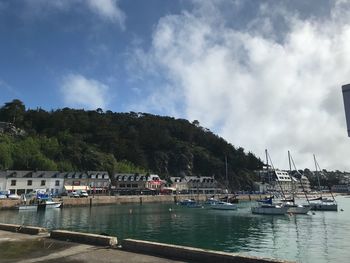 Boats moored at harbor against sky