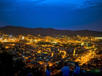 High angle view of illuminated cityscape against sky at night