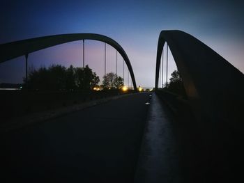 Road by bridge against sky during sunset