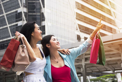 Smiling friends enjoying shopping in city