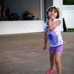 Cute girl dancing on footpath