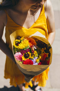 High angle view of woman holding bouquet outdoors