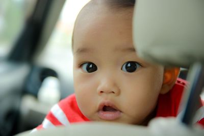 Close-up portrait of baby boy in car
