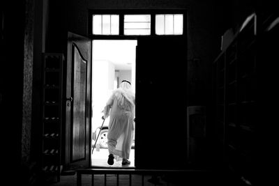Rear view full length of senior man walking at mosque doorway