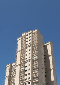 Low angle view of modern buildings against clear blue sky