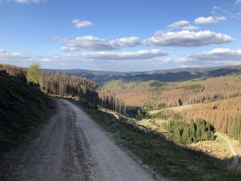 Dirt road along landscape and against sky