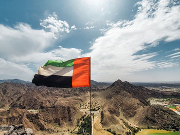Scenic view of flag on mountain against sky