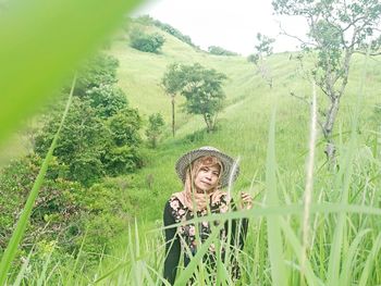 Portrait of woman by tree on field