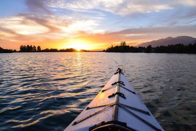 Boat sailing in sea at sunset