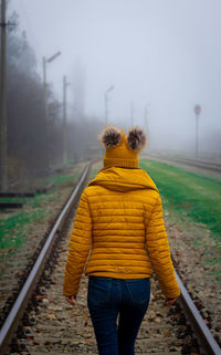 Rear view of girl on railroad track