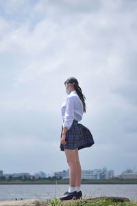 Woman standing by sunglasses against sky