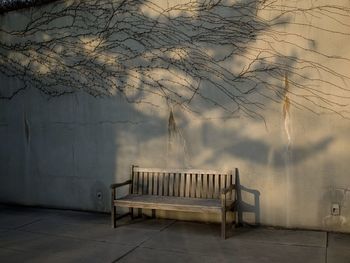 Empty bench against wall