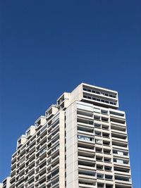 Low angle view of modern building against clear blue sky