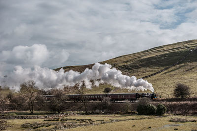 Side view of steam engine train on landscape