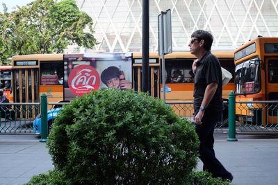 Man standing by tree in city