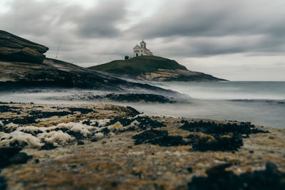 Scenic view of sea and mountains against sky