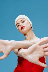 Low angle view of young woman against clear blue sky