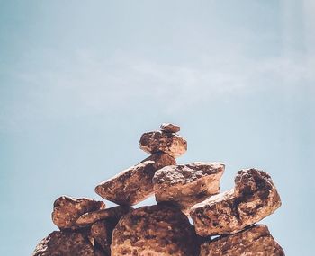 Low angle view of stack on rock against sky
