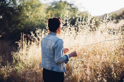 Rear view of woman standing on field