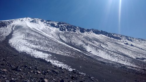 Scenic view of snowcapped mountains against blue sky