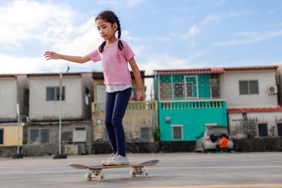 Full length of girl standing against sky in city