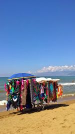 Multi colored umbrellas hanging on beach against blue sky