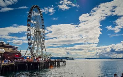 View of ferris wheel against cloudy sky