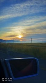 Road seen through car windshield during sunset