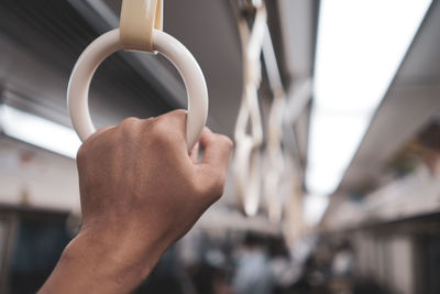 Close-up of hand holding handle in train