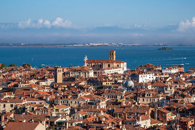 High angle view of townscape by sea against sky