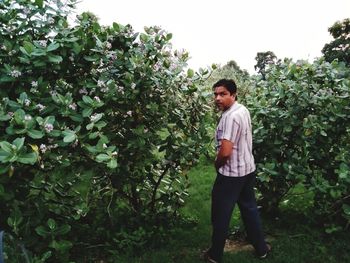 Portrait of young man standing against plants