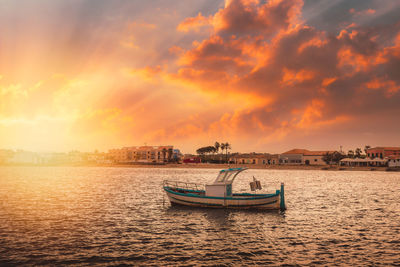 Boats in sea against sky during sunset