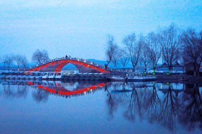 Illuminated bridge by lake tai against sky