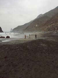 People on beach against sky