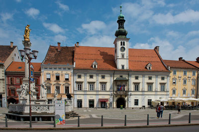 Buildings in city against cloudy sky