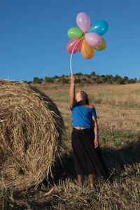 Rear view of man with balloons in field