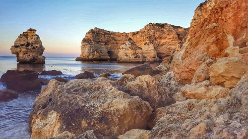 View of rocky beach against clear sky