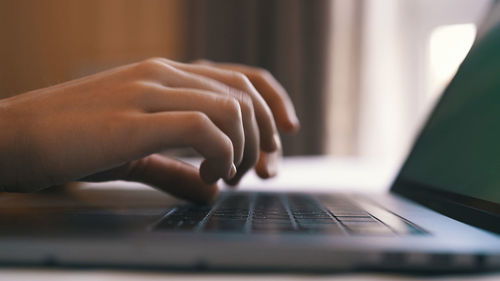 Cropped hands using laptop on table