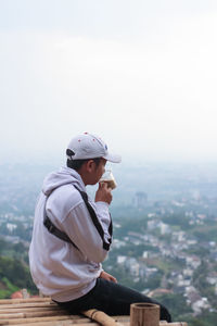 Side view of young man looking at cityscape