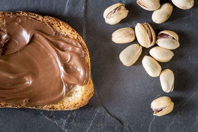 High angle close-up of bread with chocolate cream and pistachios