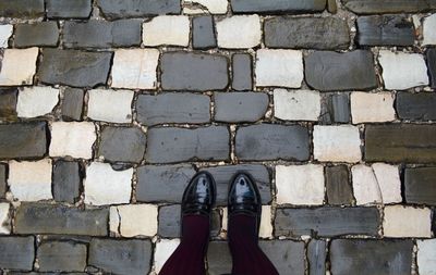 Low section of woman standing on paving stone