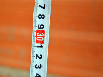 High angle close up of measuring tape against brick wall
