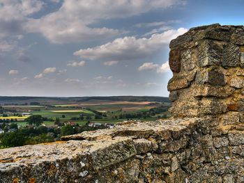 View of rocks and landscape against cloudy sky