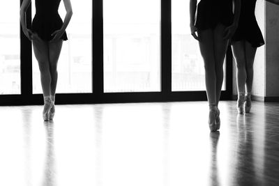 Low section of female ballerinas tiptoeing